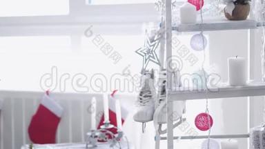 时尚的白色圣诞内部装饰阶梯，袜子，蜡烛，花环，冬季溜冰鞋靠窗户。 慢慢慢慢